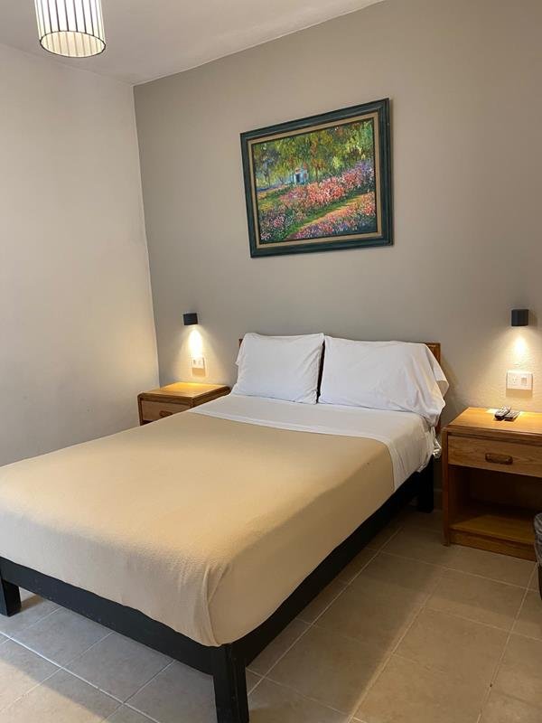 Cama matrimonial con cuadro de flores