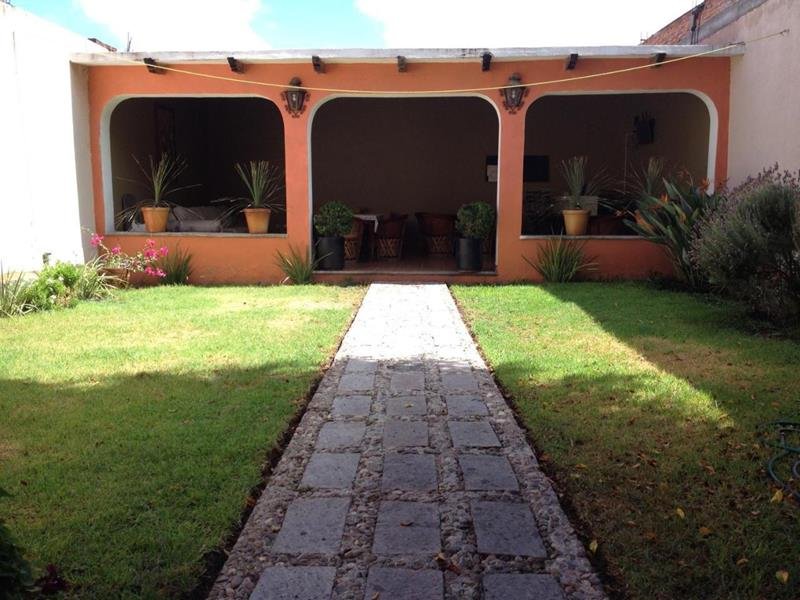 Jardín con pasto y sendero hacia el portal